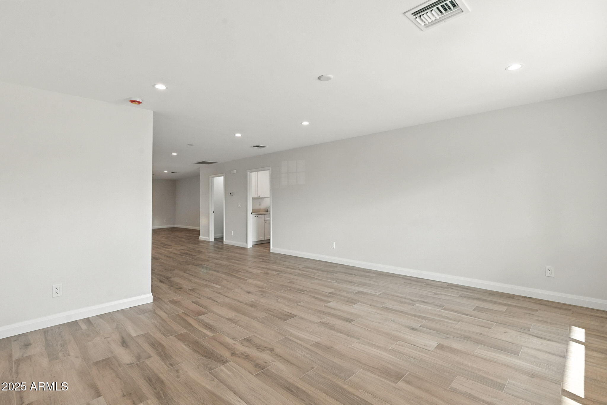 2814 North 51st Street Phoenix, AZ 85008 - Photo 6 of 50 a view of an empty room with wooden floor