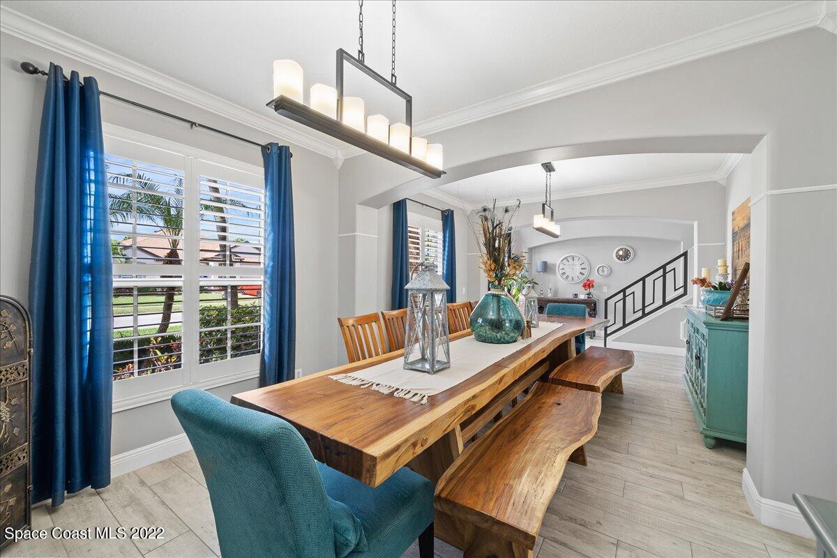 4225 Fenrose Circle Melbourne, FL 32940 - Photo 11 of 49 a dining room with wooden floor a chandelier a wooden table and chairs