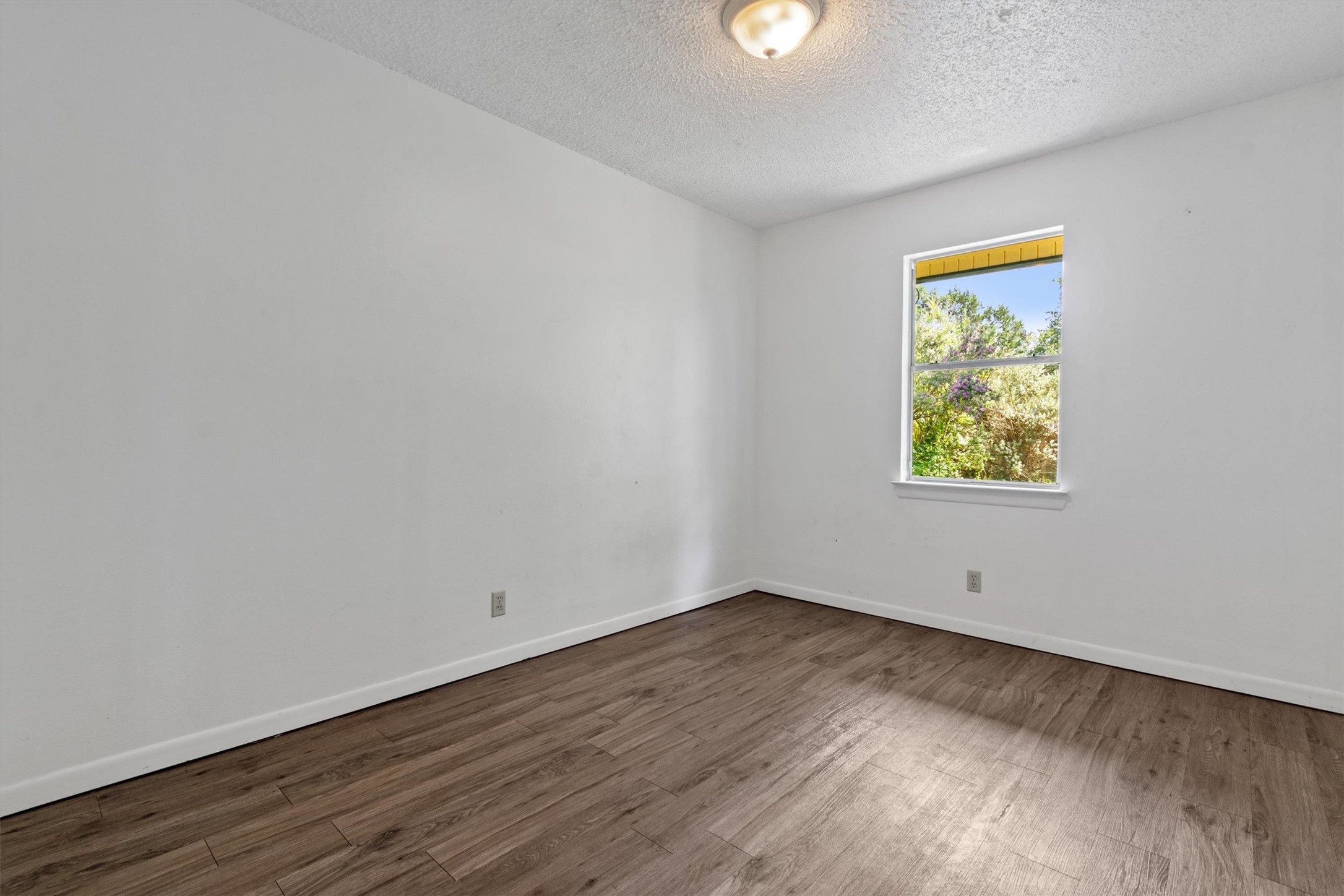 6 El Sol Road Wimberley, TX 78676 - Photo 9 of 20 Sun-filled room featuring rich wood flooring and expansive views of the outdoors.