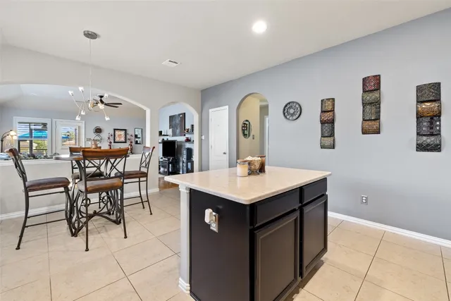 a living room with stainless steel appliances kitchen island a table and chairs in it