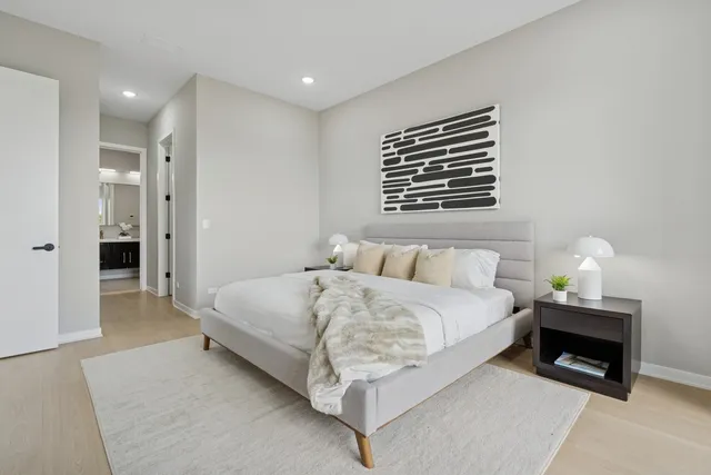 a spacious bedroom with a bed and a wall painting