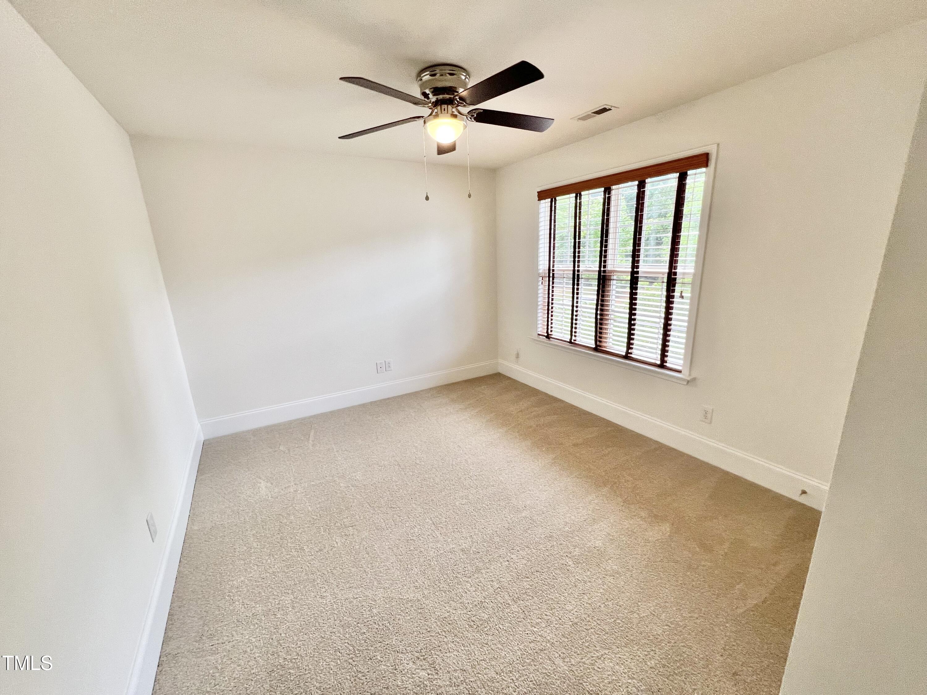 12221 Fox Valley Street Raleigh, NC 27614 - Photo 25 of 29 an empty room with a ceiling fan and a window