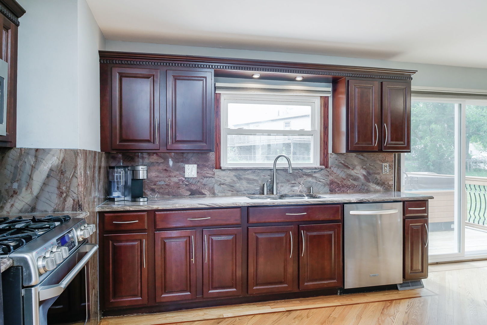 421 North Braintree Drive Schaumburg, IL 60169 - Photo 11 of 23 a kitchen with granite countertop a sink stove and cabinets