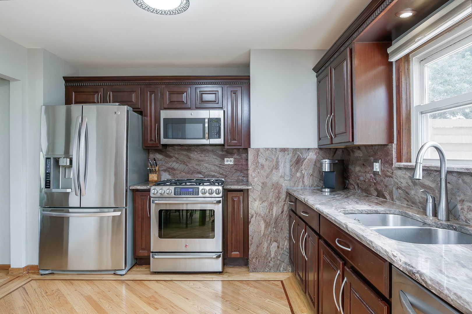 421 North Braintree Drive Schaumburg, IL 60169 - Photo 12 of 23 a kitchen with stainless steel appliances granite countertop a sink stove and refrigerator