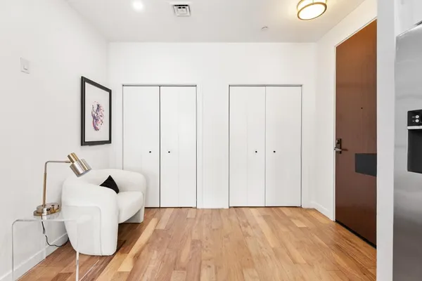 a view of a hallway with wooden floor and furniture