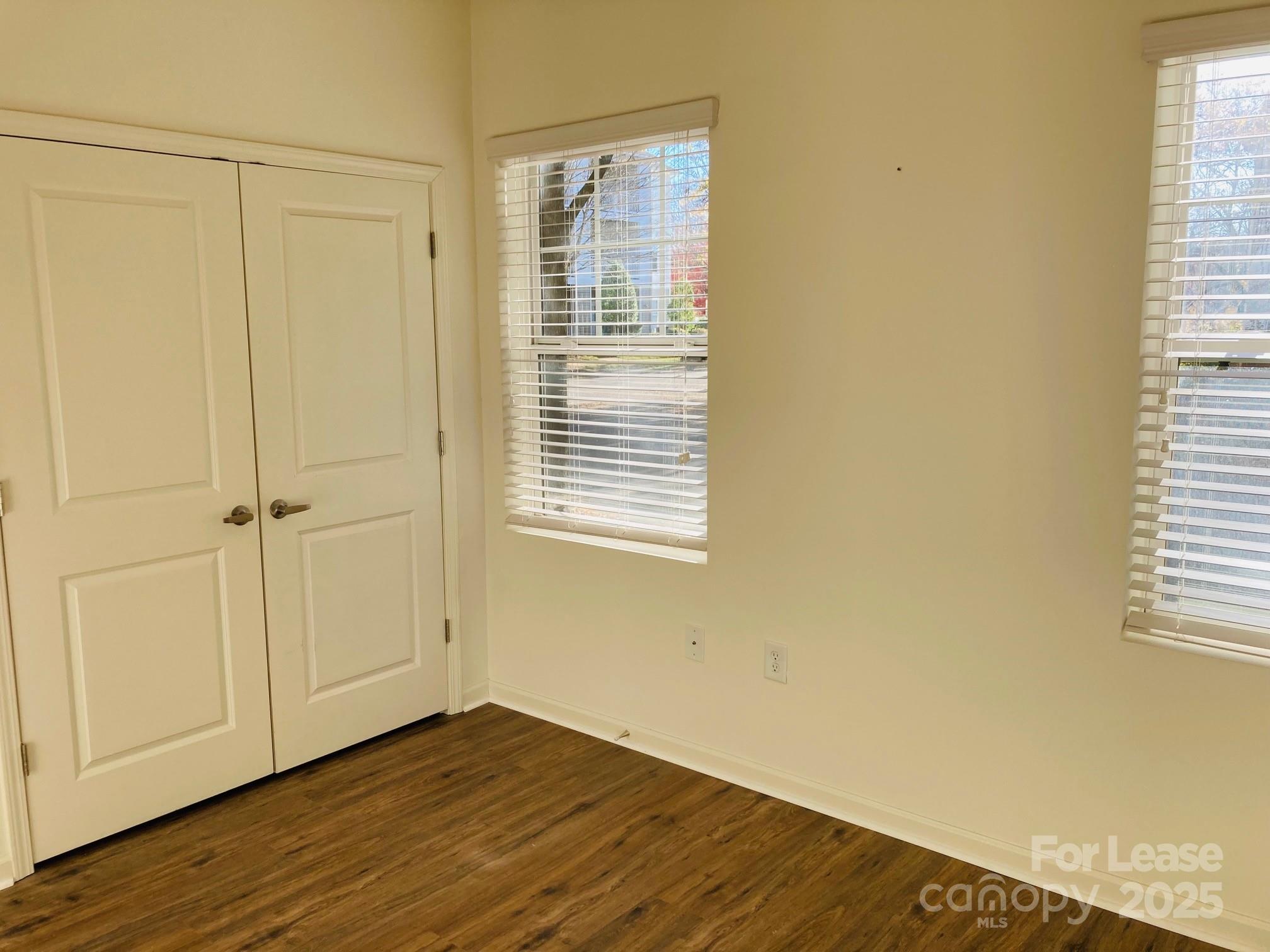 17905 Delmas Drive, Unit 101 Cornelius, NC 28031 - Photo 9 of 17 a view of an empty room with wooden floor and a window