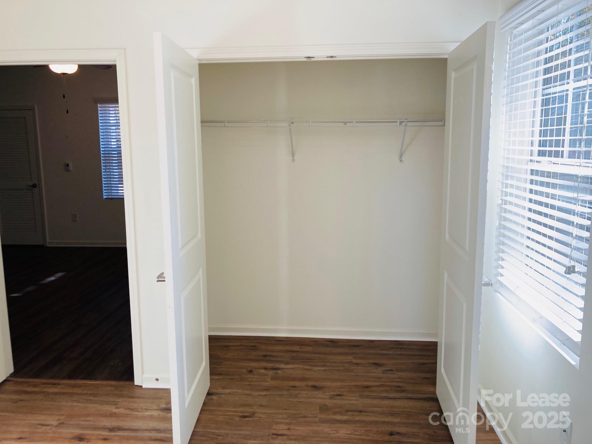 17905 Delmas Drive, Unit 101 Cornelius, NC 28031 - Photo 10 of 17 a view of an empty room with wooden floor and a window