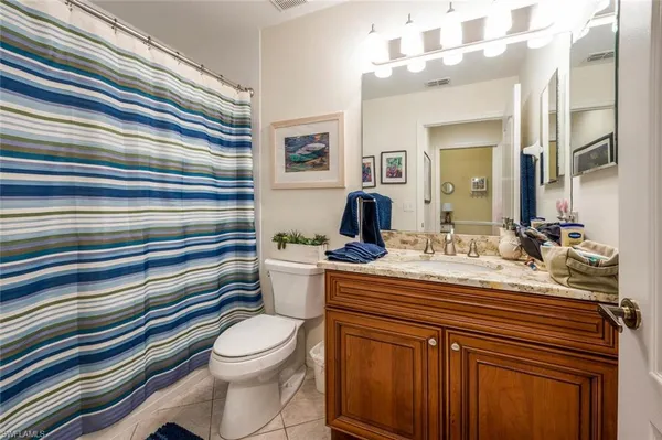 a bathroom with a sink toilet mirror and shower curtains