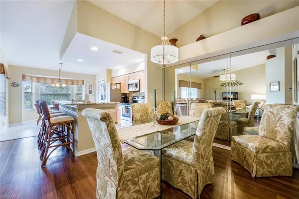 a view of a dining room with furniture a chandelier and wooden floor