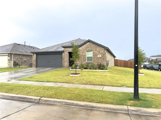 a view of a house with a yard and a garage