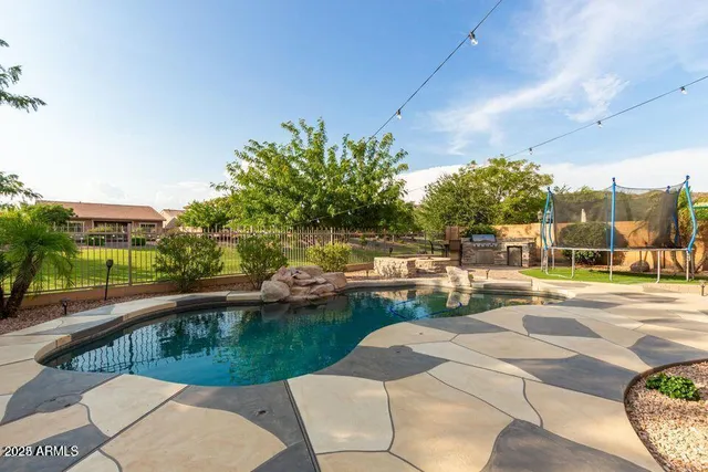 a view of a swimming pool with a patio and garden
