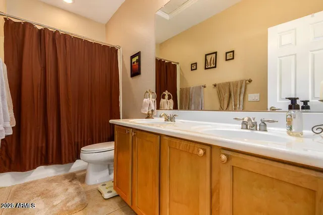 a bathroom with double vanity sink a toilet and a mirror