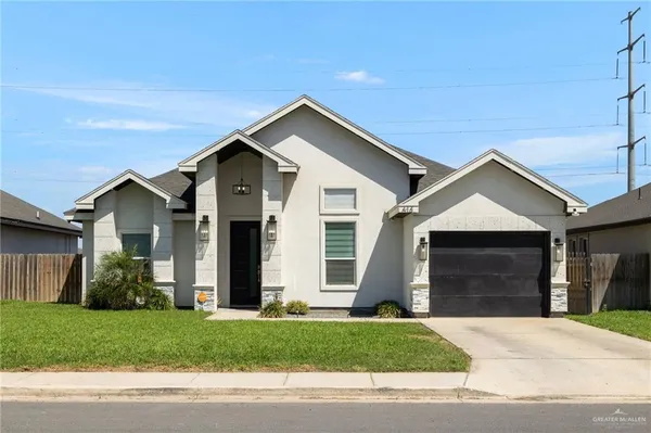 a front view of a house with a garden and garage