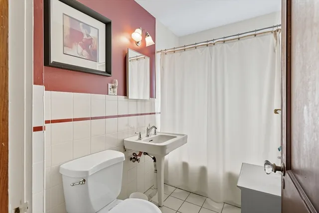 a bathroom with a sink and mirror with toilet