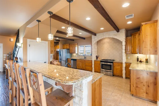 a kitchen with stainless steel appliances kitchen island granite countertop a sink and stove