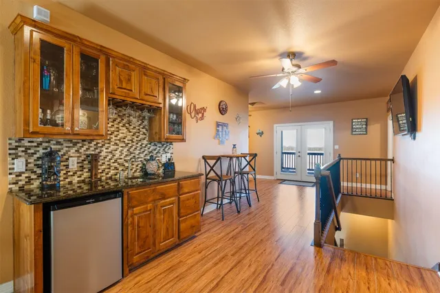 a kitchen with stainless steel appliances granite countertop hardwood floor sink stove dining table and chairs