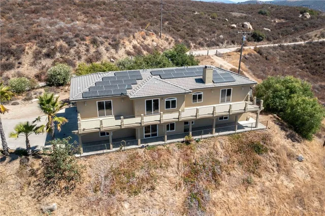 an aerial view of a house with a yard and sitting area