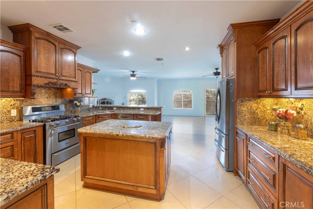 19075 Caesar Drive Ramona, CA 92065 - Photo 21 of 75 a kitchen with stainless steel appliances granite countertop wooden cabinets a stove and a sink