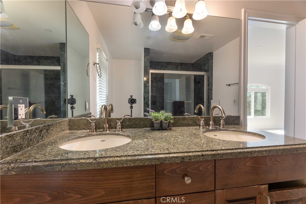 19075 Caesar Drive Ramona, CA 92065 - Photo 39 of 75 a bathroom with a granite countertop sink and a mirror