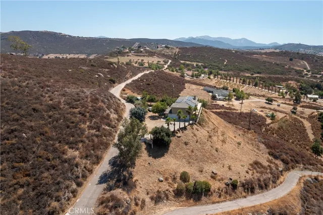 an aerial view of a house with a yard and lake view