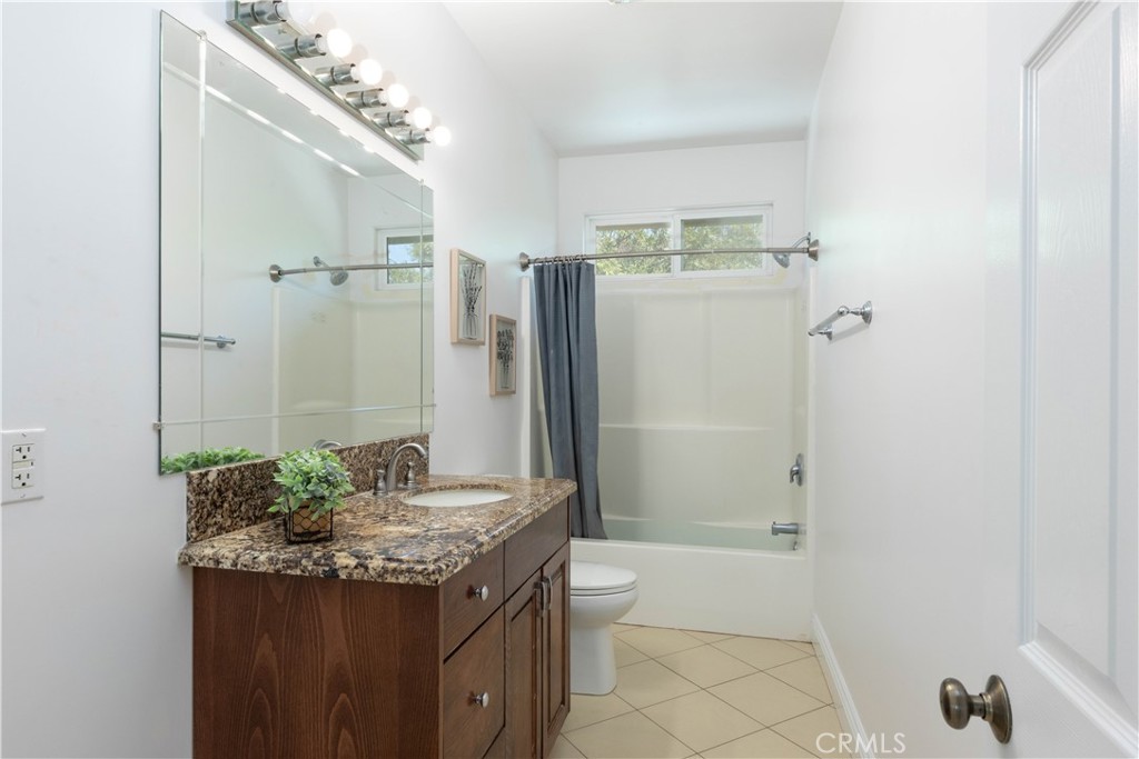 19075 Caesar Drive Ramona, CA 92065 - Photo 58 of 75 a bathroom with a granite countertop sink and a mirror