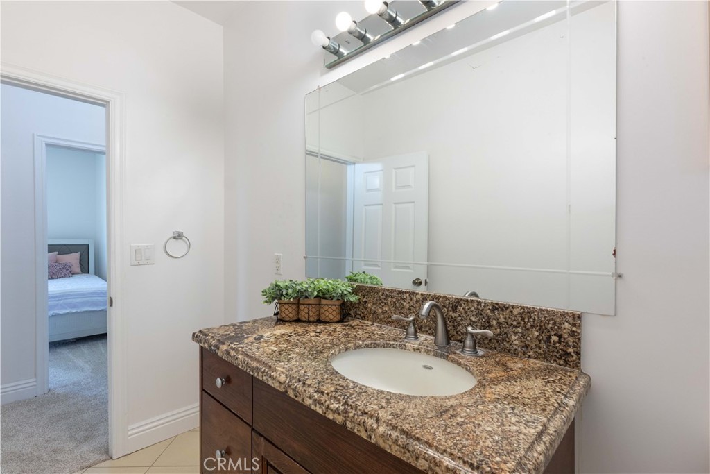 19075 Caesar Drive Ramona, CA 92065 - Photo 59 of 75 a bathroom with a granite countertop sink and a mirror