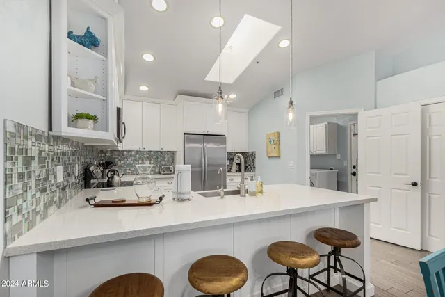 a kitchen with cabinets a sink and chairs