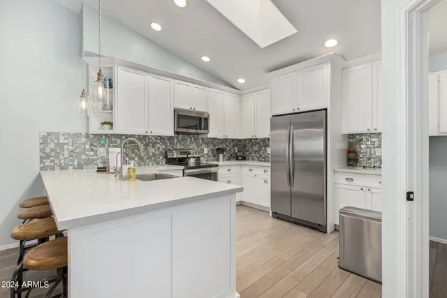 a kitchen with white cabinets stainless steel appliances and sink
