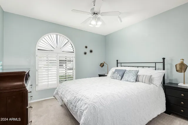 a bedroom with a large bed and chandelier