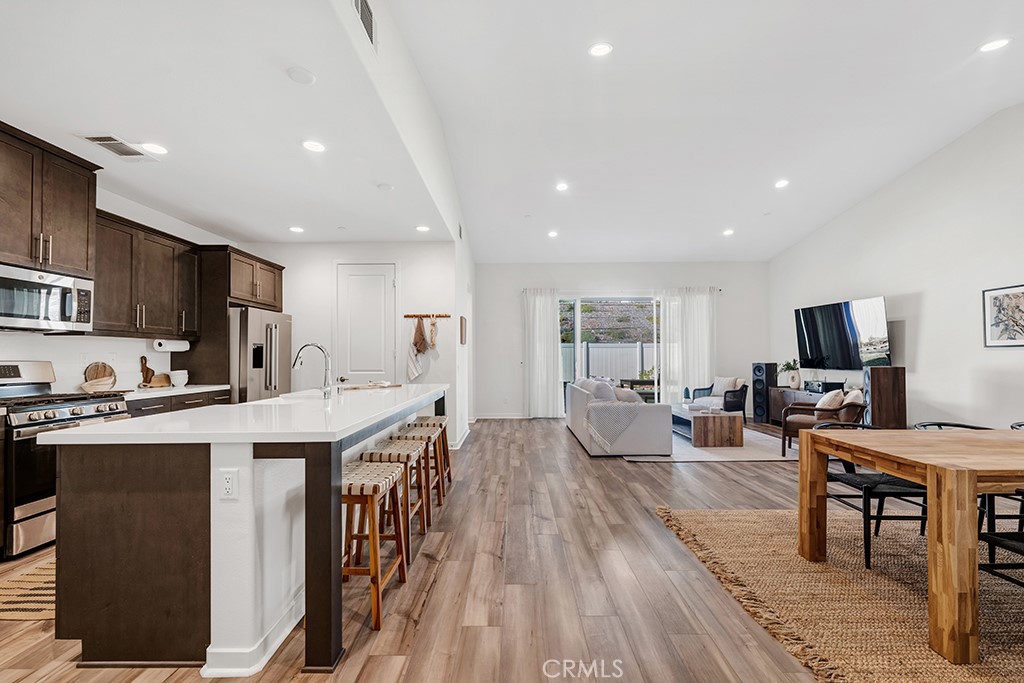 28536 Daybreak Way Saugus, CA 91350 - Photo 3 of 32 a living room with stainless steel appliances kitchen island granite countertop a sink a stove a dining table and chairs