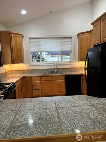 a kitchen with granite countertop cabinets and window