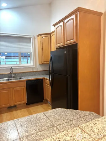a kitchen with granite countertop a refrigerator and a sink