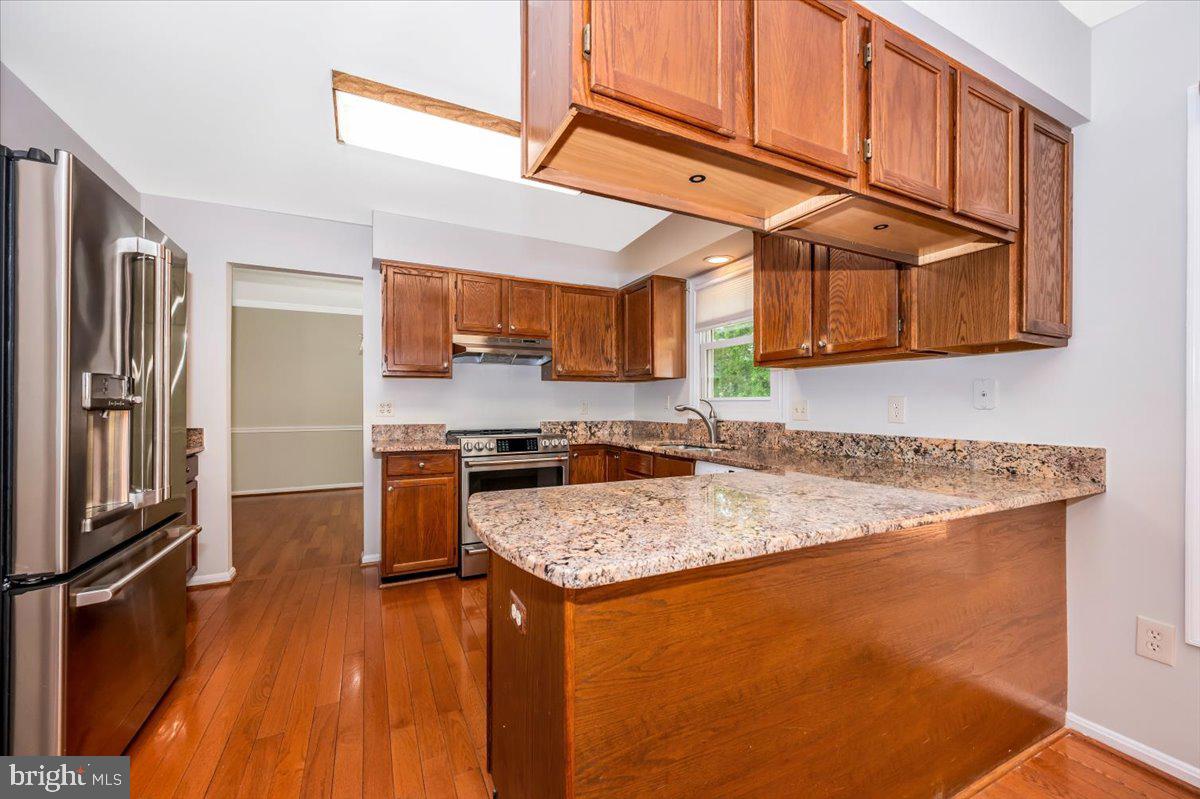 1402 Partridge Lane Bowie, MD 20721 - Photo 14 of 56 a kitchen with stainless steel appliances granite countertop a refrigerator a stove and a sink