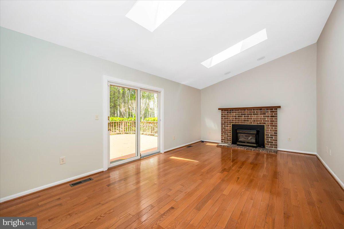 1402 Partridge Lane Bowie, MD 20721 - Photo 20 of 56 a view of an empty room with wooden floor fireplace and a window