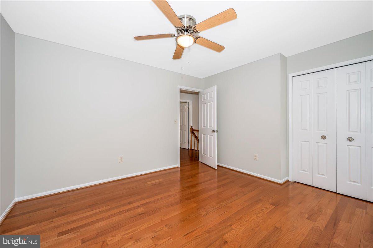 1402 Partridge Lane Bowie, MD 20721 - Photo 31 of 56 an empty room with wooden floor and a ceiling fan