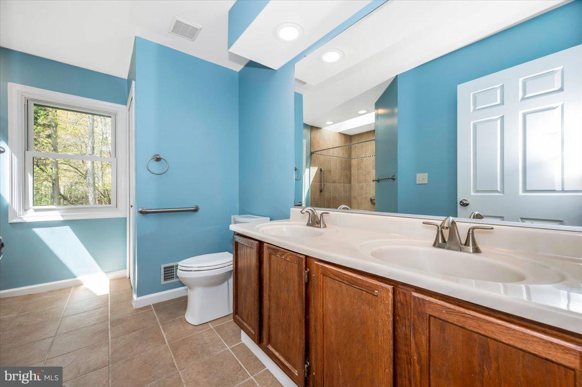 1402 Partridge Lane Bowie, MD 20721 - Photo 34 of 56 a bathroom with a double vanity sink toilet and a mirror