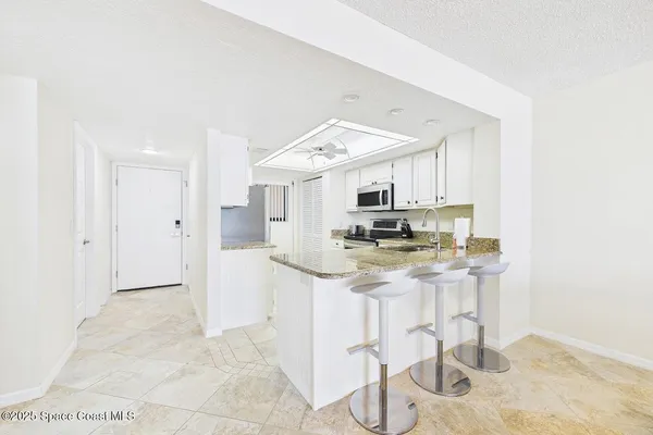 a kitchen with stainless steel appliances kitchen island granite countertop a sink and cabinets