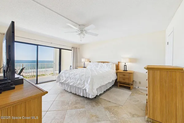 a spacious bedroom with a bed and large windows