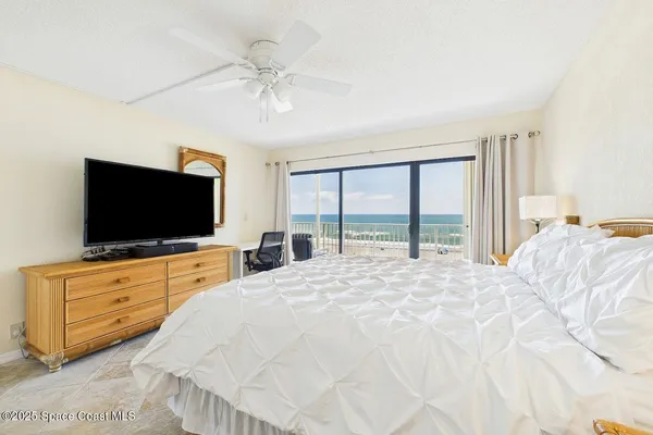 a bedroom with a bed and a flat screen tv on dresser