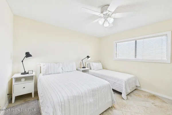 a bedroom with a white bed and a ceiling fan