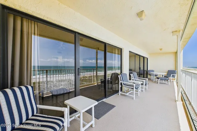 a balcony with chairs and outdoor view