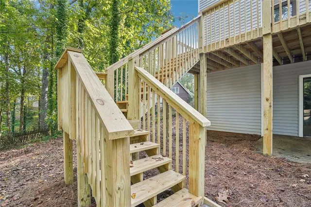 a view of a house with wooden fence next to a yard