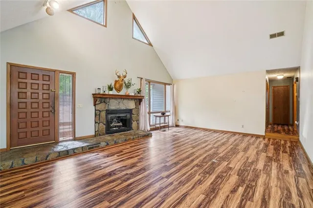 a living room with wooden floor and large windows