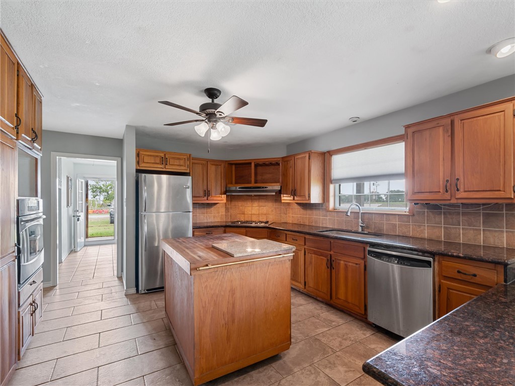 17645 Highway 6 Navasota, TX 77868 - Photo 16 of 30 a kitchen with stainless steel appliances granite countertop a stove a sink dishwasher a refrigerator and cabinets with wooden floor