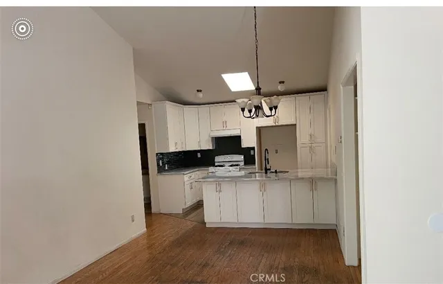 a kitchen with kitchen island white cabinets and wooden floor