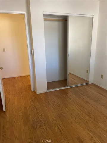 an empty room with wooden floor and closet