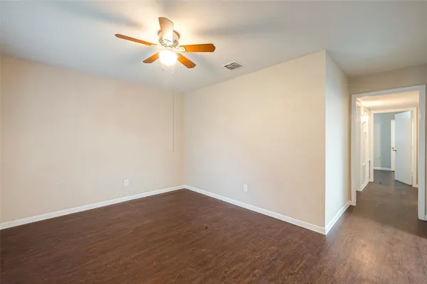 a view of an empty room with wooden floor