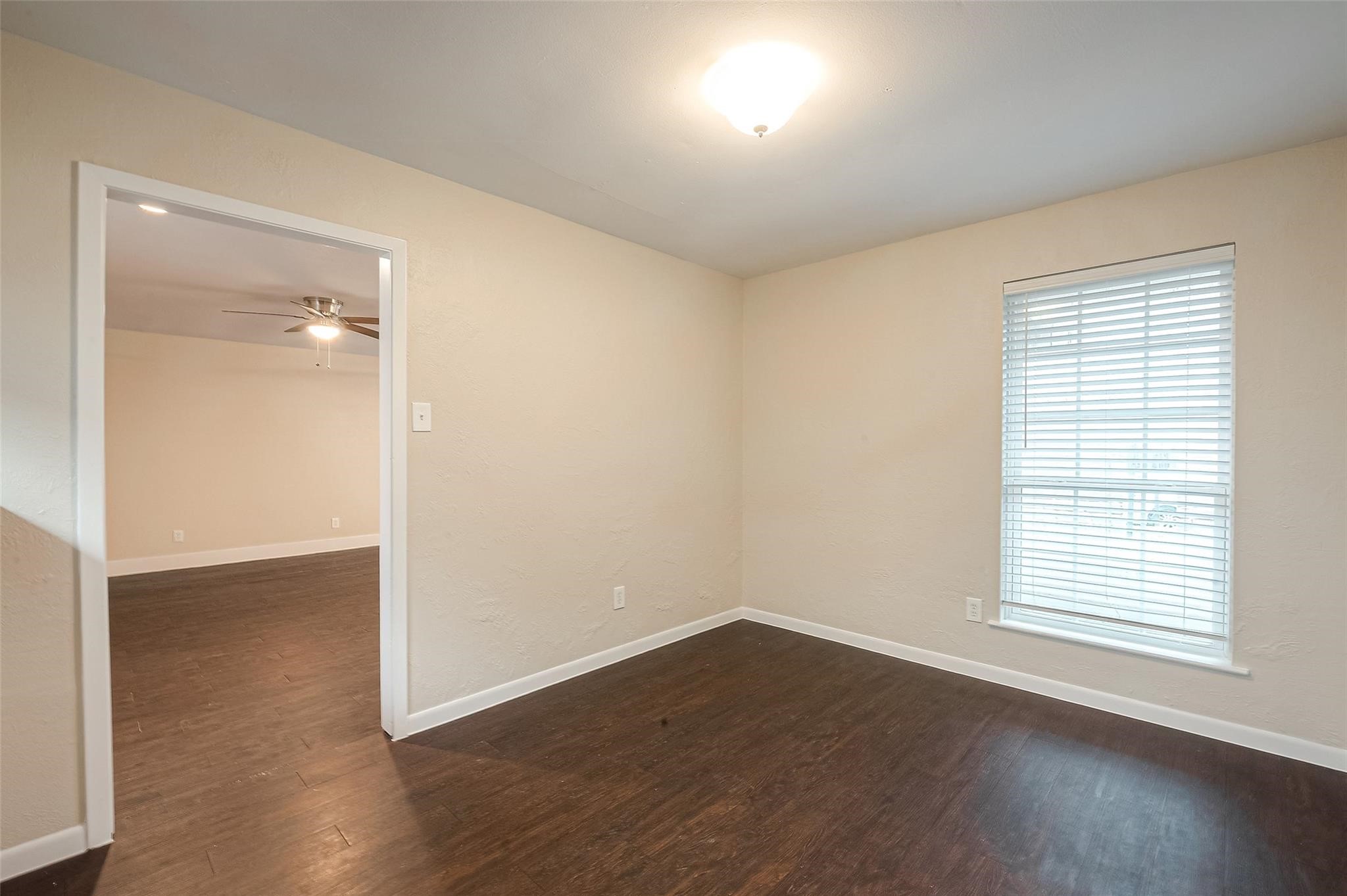 1447 Willow Rock Road Houston, TX 77088 - Photo 9 of 37 an empty room with wooden floor and windows