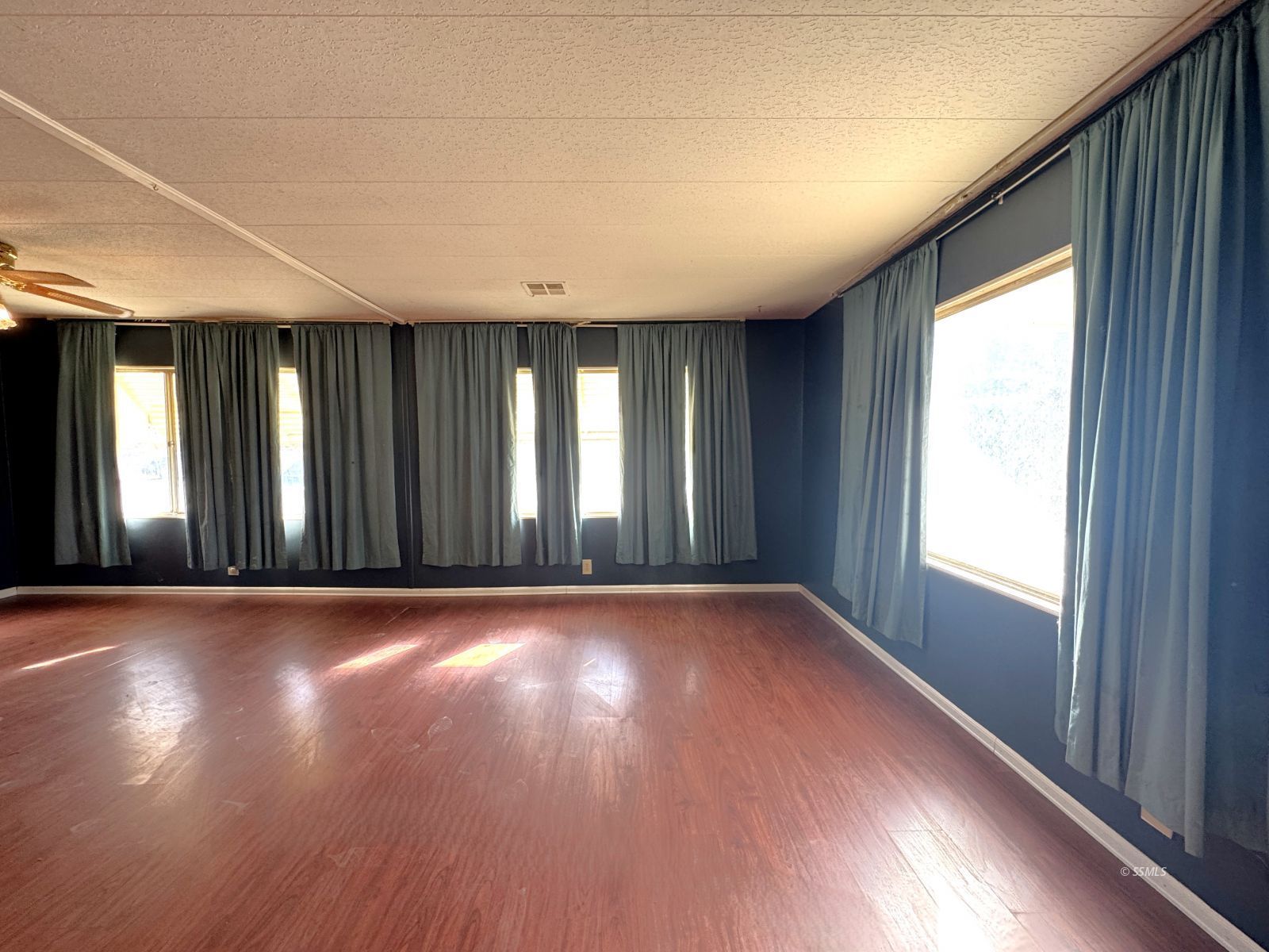1320 South Brady Street Ridgecrest, CA 93555 - Photo 6 of 29 an empty room with wooden floor and windows