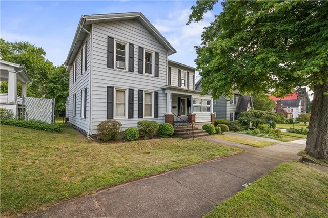 a front view of a house with a garden